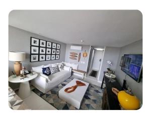 a living room with a white couch and a table at Vitória Marina Flat in Salvador +20 photos