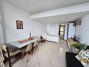 a living room with a table and a couch at Vitória Marina Flat in Salvador