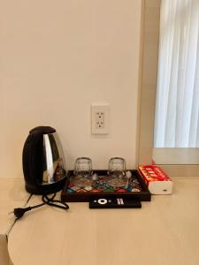 a tray with two glasses and a book on the floor at Blue Hotel Sunset Town Phu Quoc in Phú Quốc
