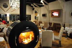 a fireplace in a restaurant with tables and chairs at Hotel Restaurant Pavillon Bleu in Olivet