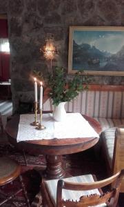 Una mesa con dos velas y un jarrón. en Vassbakken Kro og Camping, en Skjolden
