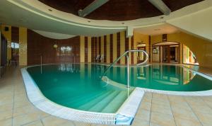 a large swimming pool in a large building at Wellness hotel Velky Meder in Veľký Meder