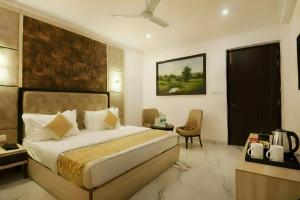 a bedroom with a large bed and a chair at Hotel Apple Park - Near Delhi Airport, Free Airport Trasnfer in New Delhi +75 photos
