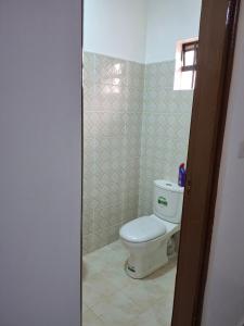 a bathroom with a white toilet in a room at BlessRoyal Home in Kitengela 