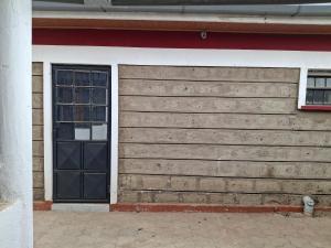 a garage with a black door and a window at BlessRoyal Home in Kitengela 
