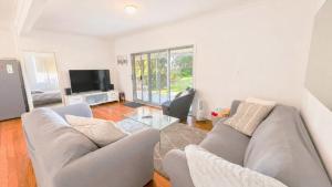 a living room with a couch and a tv at On The Beach in Wooli