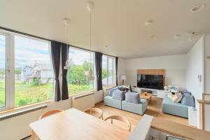 a living room with a couch and a tv at Suzuran Haus in Higashikawa
