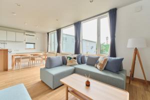 a living room with a blue couch and a table at Suzuran Haus in Higashikawa