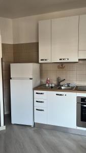 a kitchen with white cabinets and a white refrigerator at Maison Sofia Mare in Silvi Marina