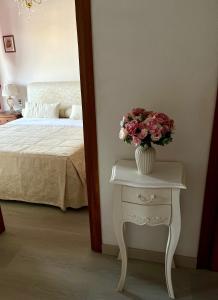 a bedroom with a table with a vase of flowers on it at Maison Sofia Mare in Silvi Marina