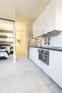 ボローニャにあるDante Suite private parkingの白いキャビネット付きのキッチン、ベッド(背景)