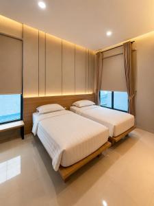 two beds in a room with two windows at Wisma Pelangi 1 in Jakarta