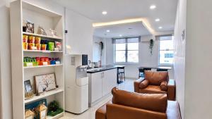 a kitchen and living room with two chairs and a table at Orange Hotel Kota Kemuning @ Shah Alam in Shah Alam