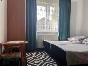 a bedroom with two beds and a window with blue curtains at Adria in Sarbinowo