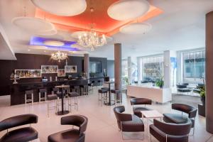 a bar in a restaurant with chairs and tables at Meliá Berlin in Berlin