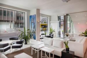 a restaurant with white furniture and tables and windows at Meliá Berlin in Berlin +52 photos