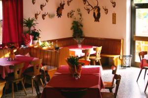 um restaurante com mesas e cadeiras com mesas vermelhas em Niederhof em Parcines
