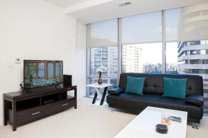 Arlington Fully Furnished Apartments in Crystal City في أرلينغتون: غرفة معيشة مع أريكة وتلفزيون