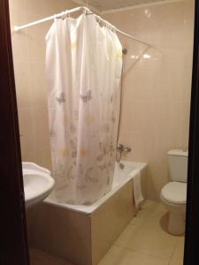 a bathroom with a shower curtain and a toilet at Hotel Vale Verde in Furnas