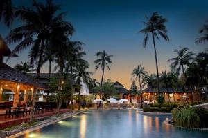 a swimming pool in a resort with palm trees at Palm Galleria Resort in Khao Lak
