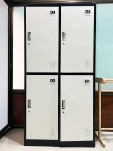 a row of white lockers in a room at Beach Yard Hostel in Ban Nua
