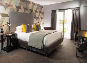 a bedroom with a large bed with yellow pillows at Malmaison Oxford in Oxford +87 photos