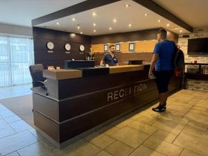 a man standing at the reception desk of a restaurant at Pirin Getaway Heaven in Razlog +22 photos