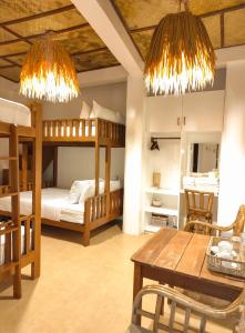 a room with two bunk beds and a table and chairs at Inbox Siargao Resort in General Luna +41 photos