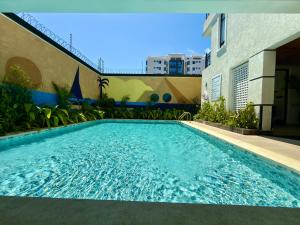 a swimming pool in front of a building at Valletta Homes- Modern 1BR, 5mins walk to Serena Beach in Mombasa