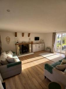 a living room with two couches and a television at La Maison Arc-en-ciel in Brigueuil-le-Chantre