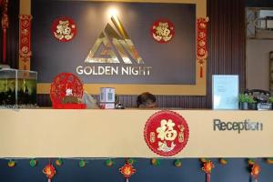a person sitting at a counter at a golden nift reception at Golden Night Hotel Sunway in Petaling Jaya