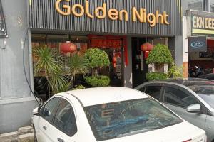 a white car parked in front of a golden night at Golden Night Hotel Sunway in Petaling Jaya