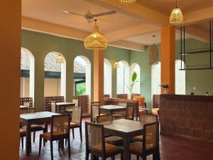 a dining room with tables and chairs and windows at Crown Valley Boutique Lifestyle Hotel, Ella in Ella