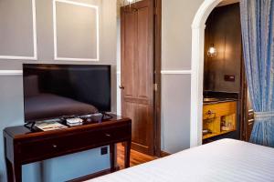 a bedroom with a bed and a flat screen tv at Quba by Montraj Pattaya, previously The Quba Hotel Pattaya in Pattaya