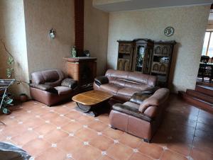 a living room with two leather chairs and a table at Вовча хижа in Khmelnytskyi