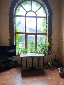 an arched window with a table with plants in front of it at Вовча хижа in Khmelnytskyi