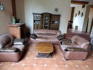 a living room with leather couches and a coffee table at Вовча хижа in Khmelnytskyi