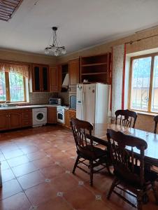 a kitchen with a table and chairs and a refrigerator at Вовча хижа in Khmelnytskyi