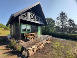 a log cabin with a wooden deck and a table at Chata Tisá in Tisá