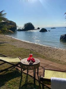 a table and chairs on a beach with the ocean at Ankavia Lodge in Sainte Marie +5 photos