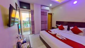 a bedroom with a large white bed with red pillows at Hotel Sea Cox in Cox's Bazar +43 photos