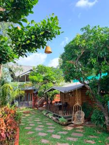 a house with a patio and a yard at CharDara Agrotourism & FarmStay in Mahabaleshwar