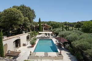 an overhead view of a swimming pool with chairs and trees at Domaine Les Roullets in Oppède