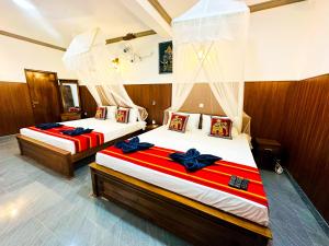 a bedroom with two beds with bows on them at Sigiriya Peacock Homestay in Sigiriya +90 photos