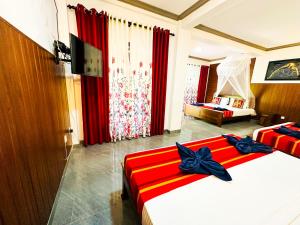 two beds in a room with red and white at Sigiriya Peacock Homestay in Sigiriya