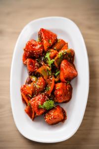 a white plate of food with chicken and broccoli at DEO SIGNATURE SUITE Hotel in Rānchī