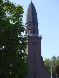 a tall tower with a clock on the top of it at Bed and Breakfast Corvel in Tilburg