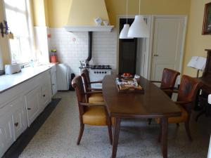 
a kitchen with a table and chairs and a refrigerator at Bed and Breakfast Corvel in Tilburg
