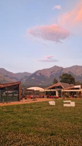 a building with a grass field and mountains in the background at Rêverie Amatrice in Amatrice
