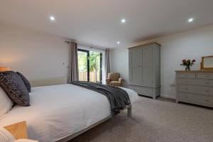 a bedroom with a bed and a dresser and a window at Warner - Treworgie Barton Cottages in Bude